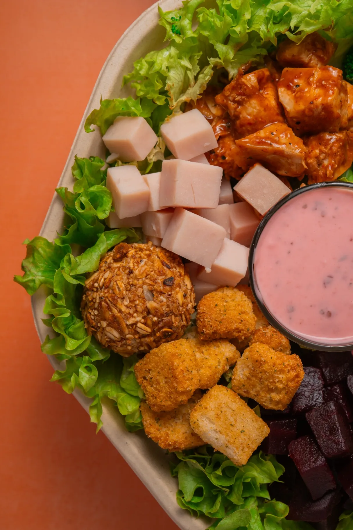 Ensalada Tasty Greens recién armada con proteína, crocante y aderezo